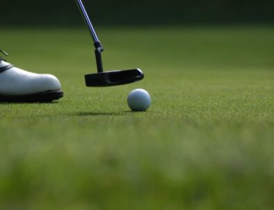 gros plan sur un club de golf qui va frapper dans une balle sur une pelouse